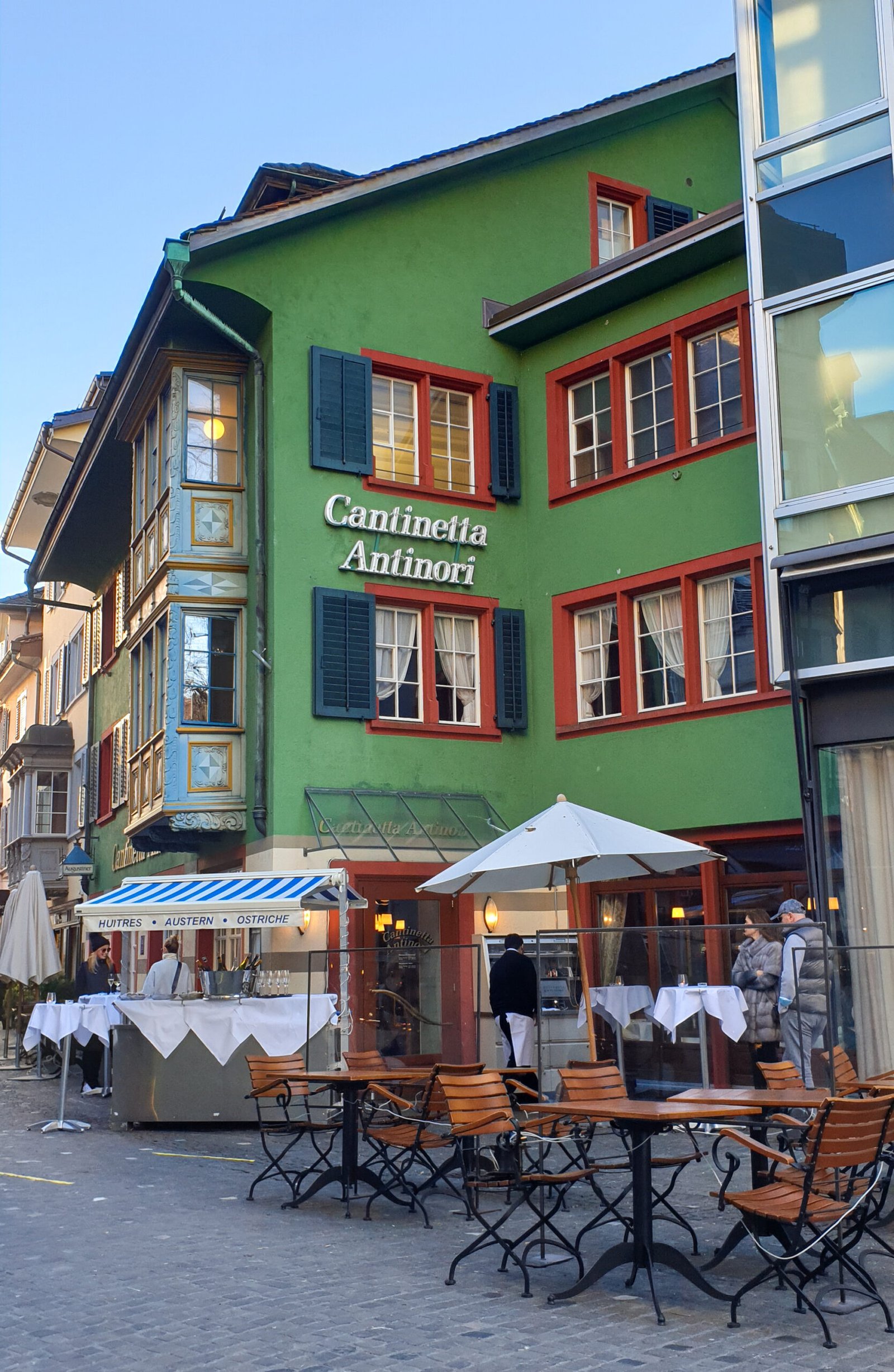 Guia de melhores restaurantes onde comer em Zurique 11 Aceitamos Viagens onde comer em zurique Prédio verde com mesas de restaurante na frente e inscrição "Cantinetta Antinori"