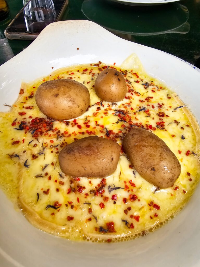 Guia de melhores restaurantes onde comer em Zurique 2 Aceitamos Viagens onde comer em zurique Um prato com reclate: queijo derretido, batata e especiarias